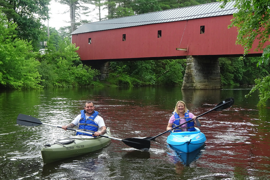 A couple on canoes under covered bridge